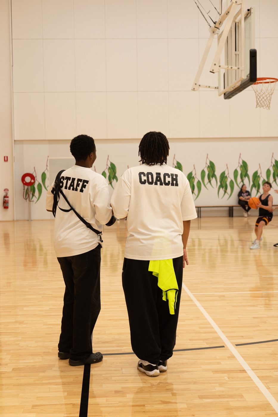 A2Z staff and coach watching a game from courtside