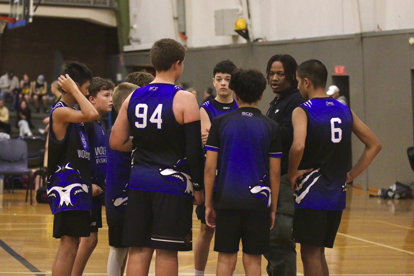 Coach talking to a junior team in a huddle